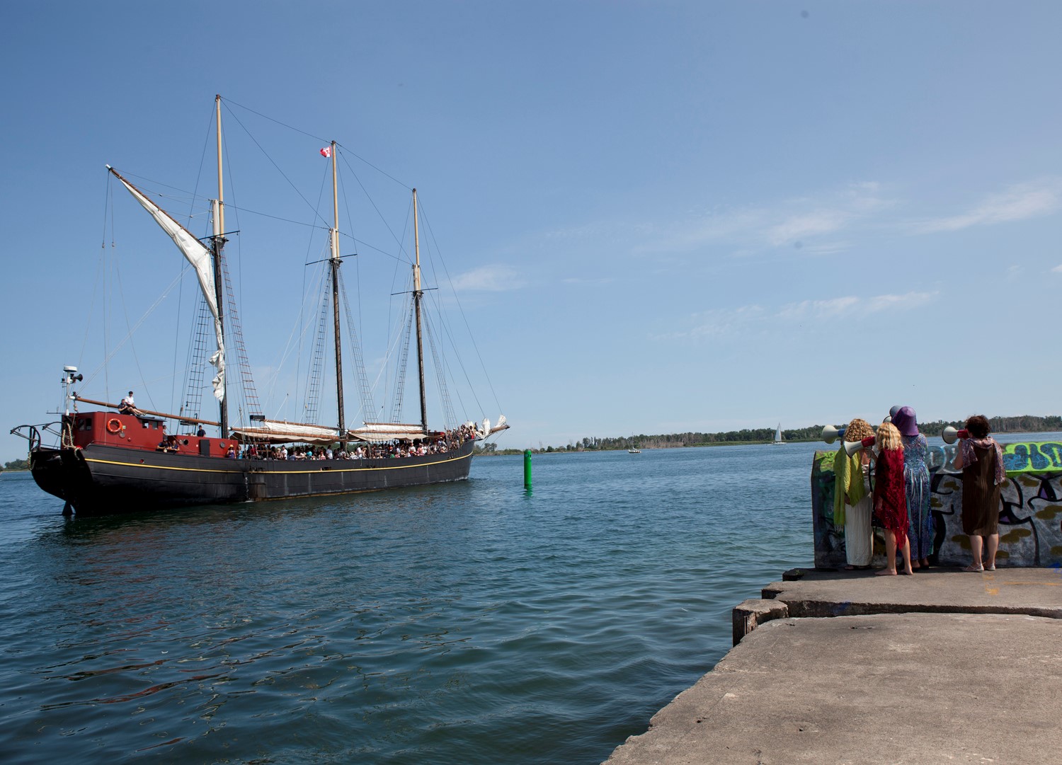 Pirate ship on water with people watching it on the water