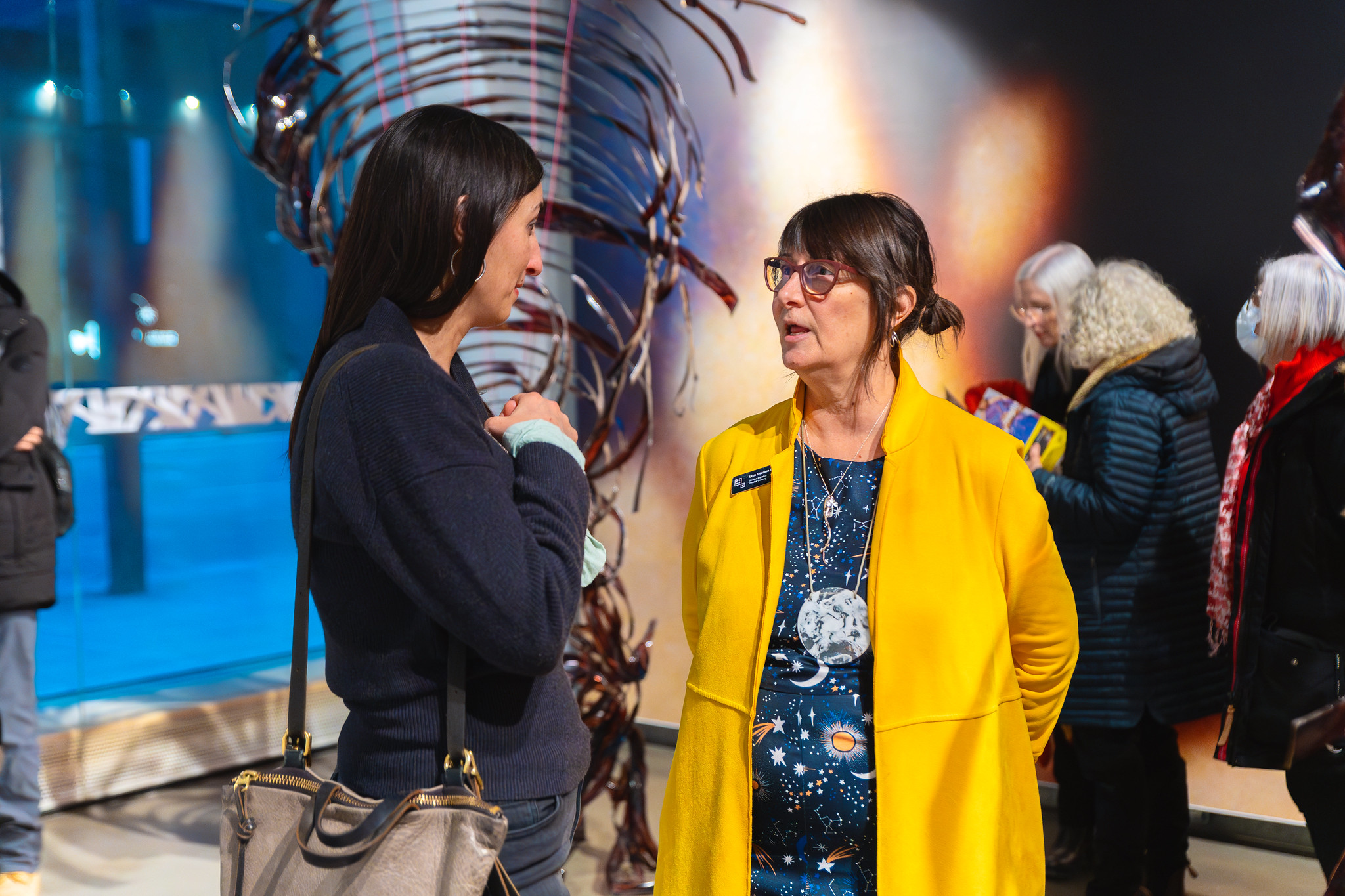 Two people talking at an art show