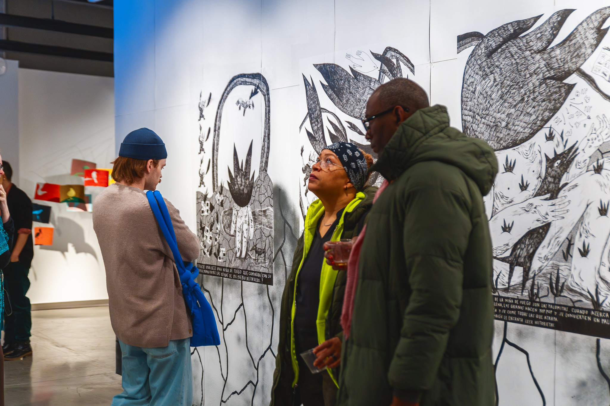 Two people in an art gallery, one looking up towards the art