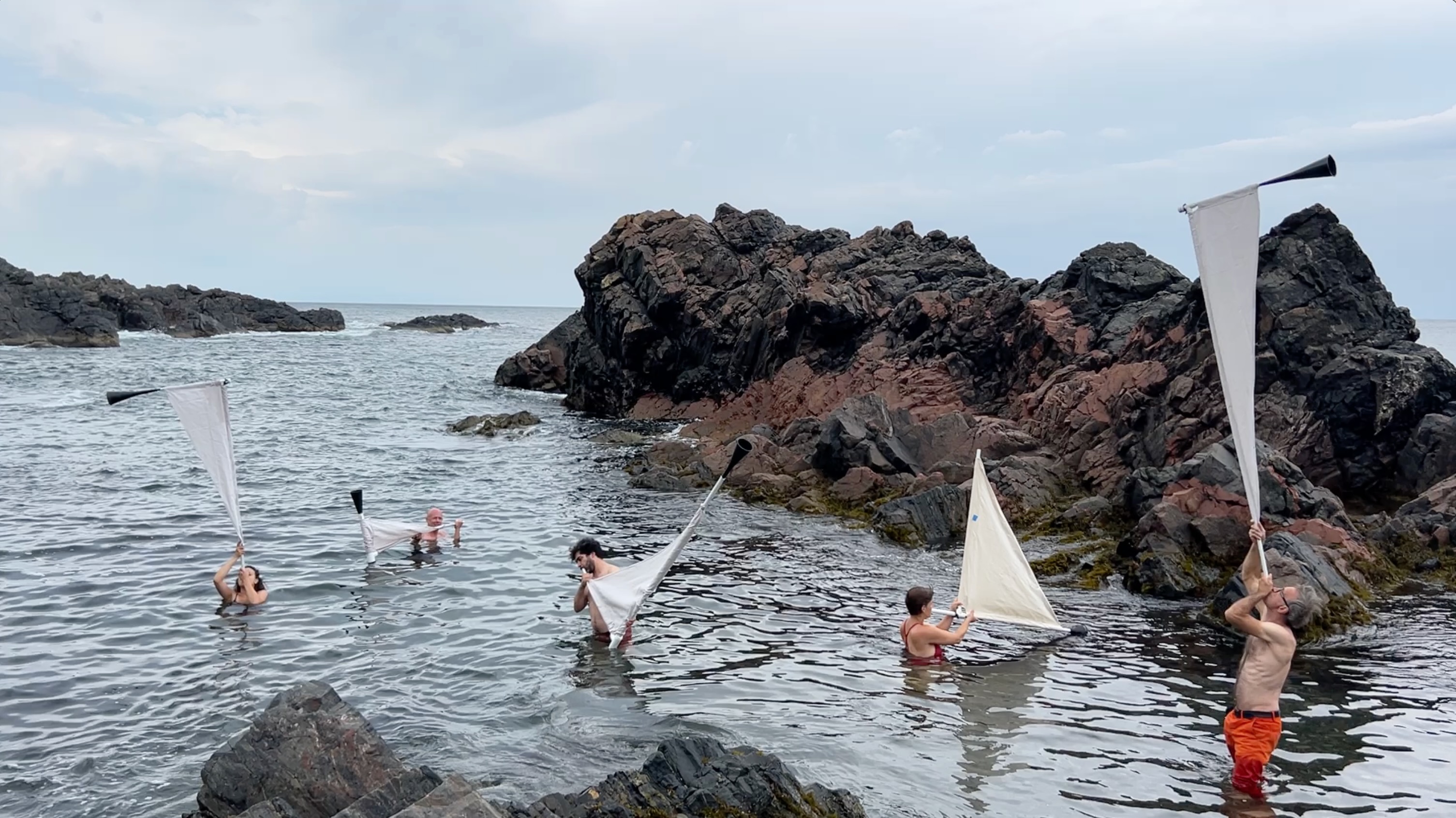 group of people blowing horns in the lake