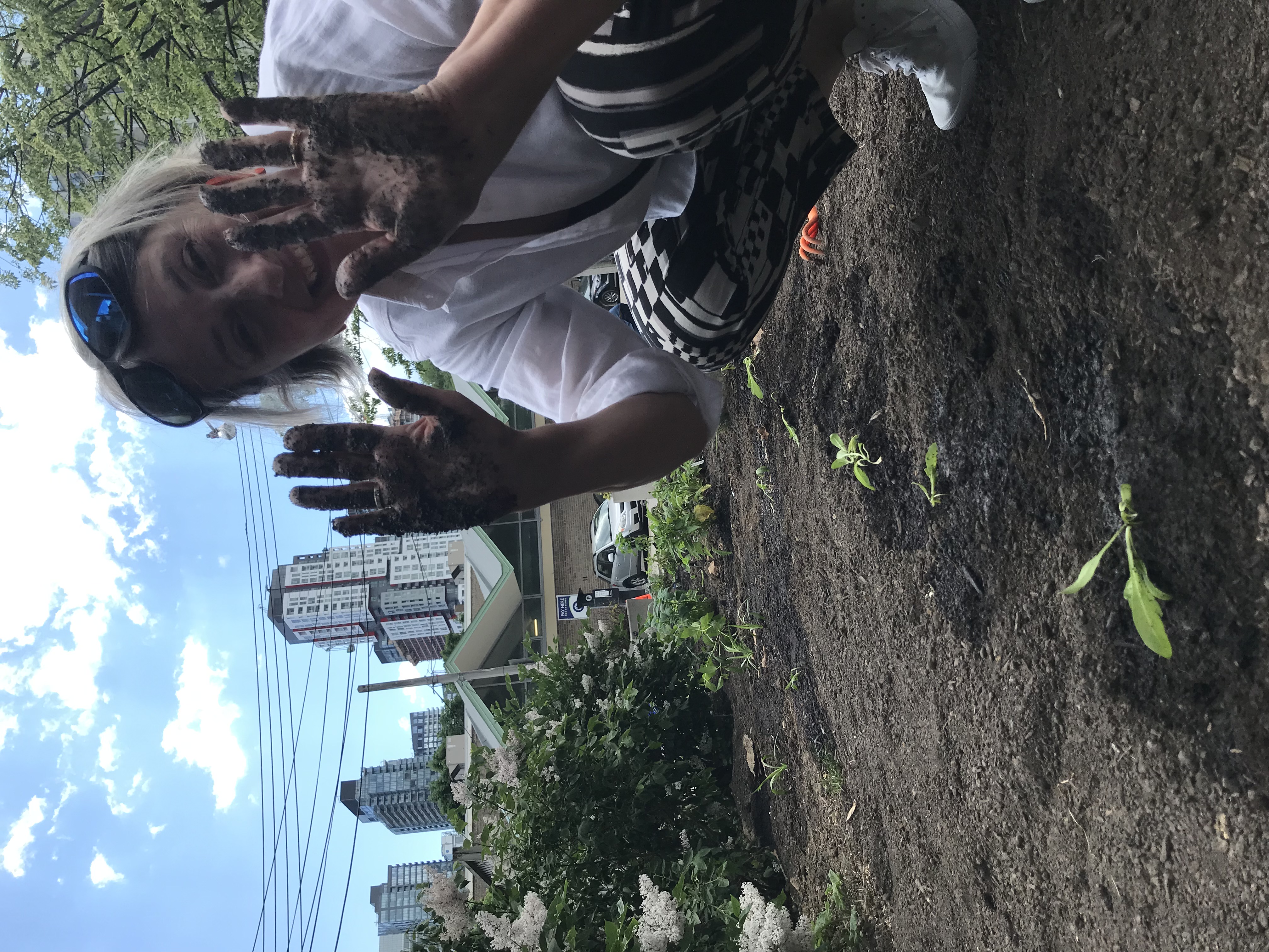 OCAD U staff smiling with soil on hands during inaugural Community Planting Day