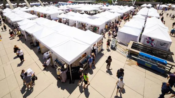 Outdoor art fair with tents and people shopping