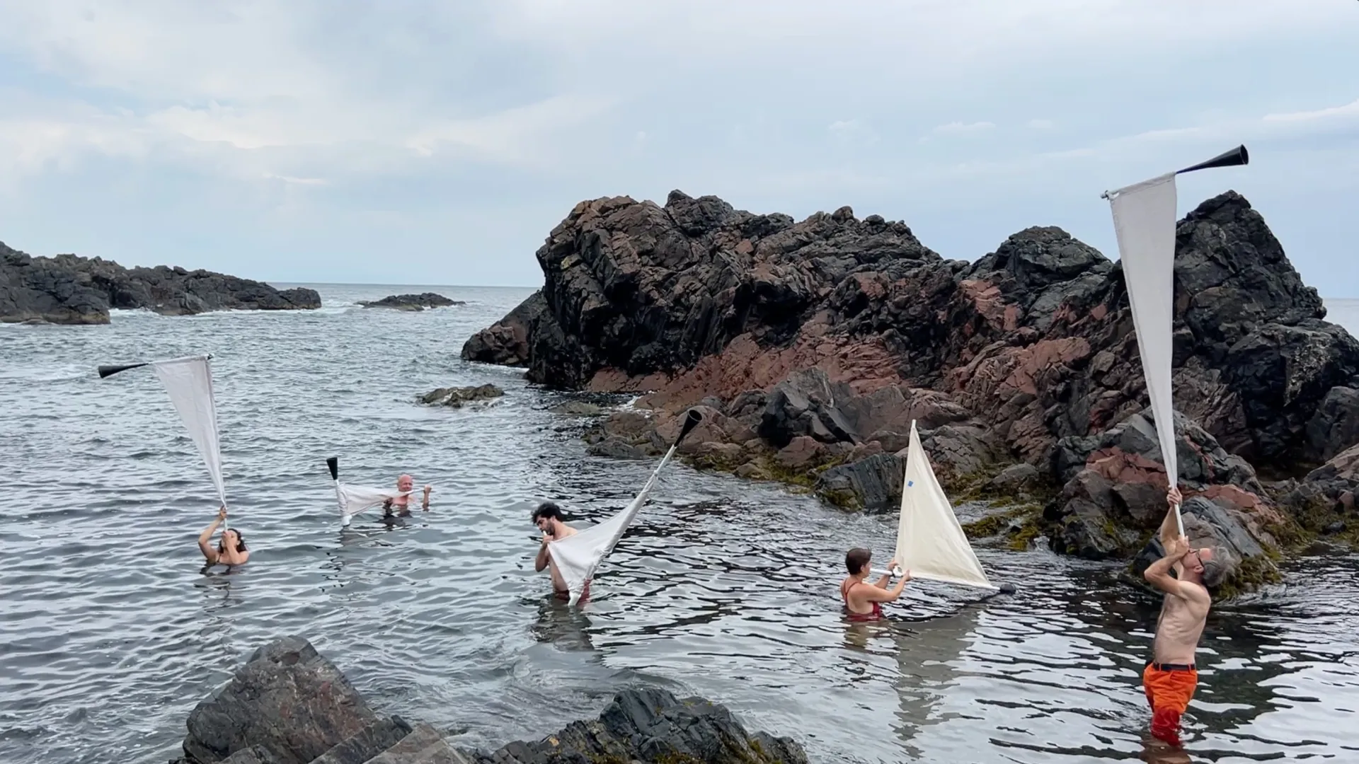 group of people blowing horns in the lake