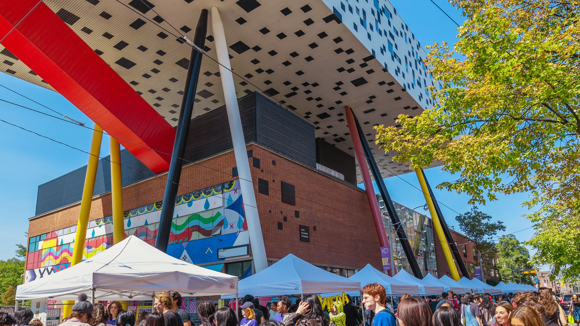 Welcome Day on McCaul St with people visiting booths and the Sharp Centre in the background.