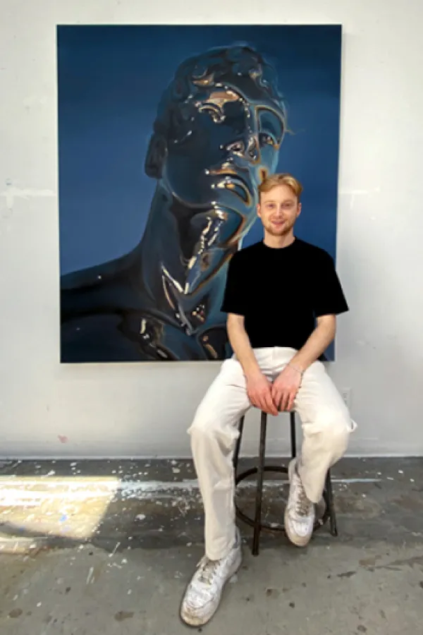 Student sitting in front of large scale painted portrait