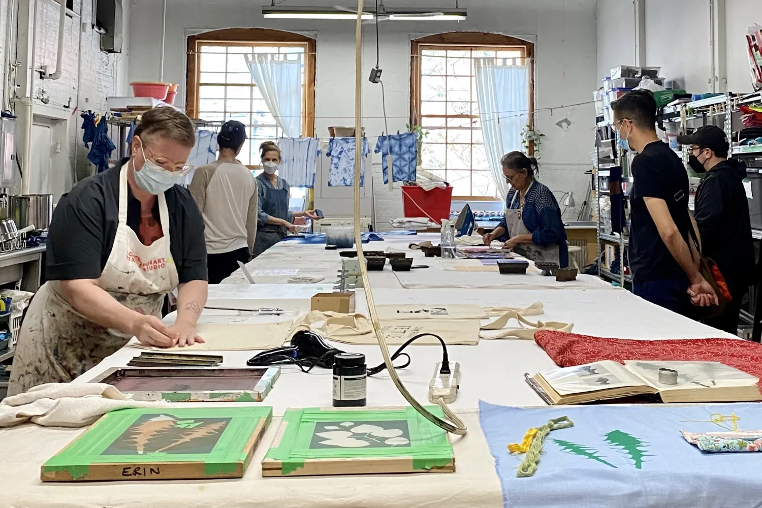 A group of people working around a table in the Contemporary Textile Studio.