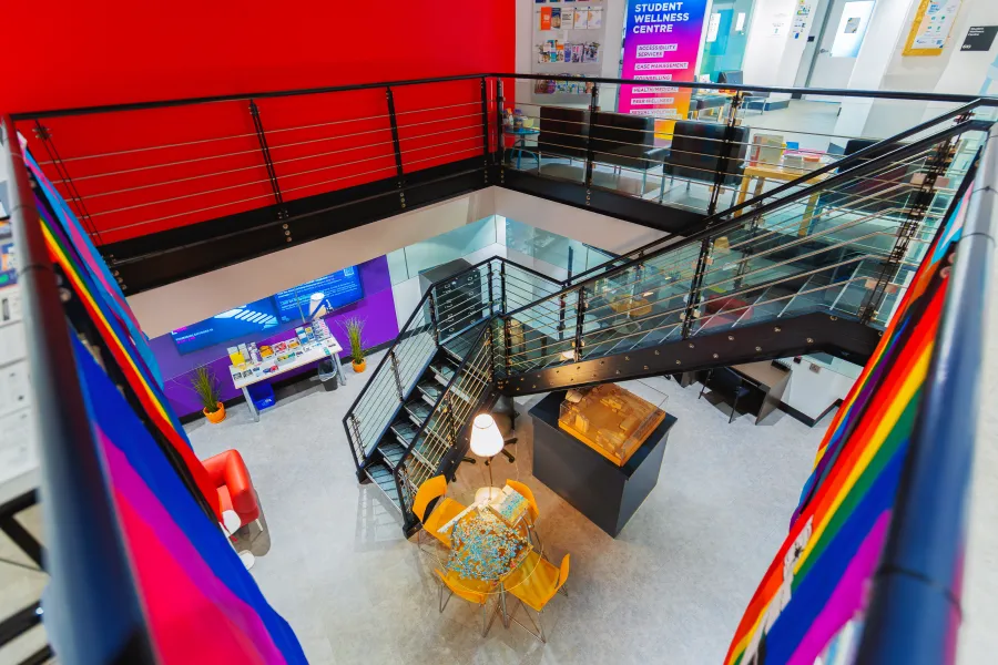 Stairwell lookingn downwareds to a room and a table.