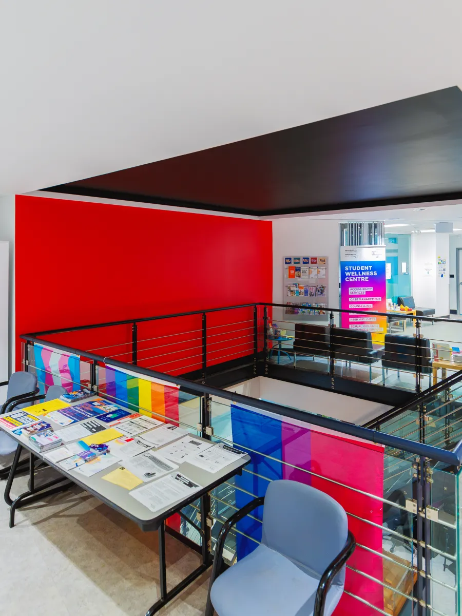 Stairwell with a black ceiling, red wall and display table.