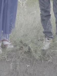 Feet standing in grass.