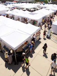 Outdoor art fair with tents and people shopping