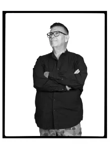 A man standing with arms crossed wearing eye glasses
