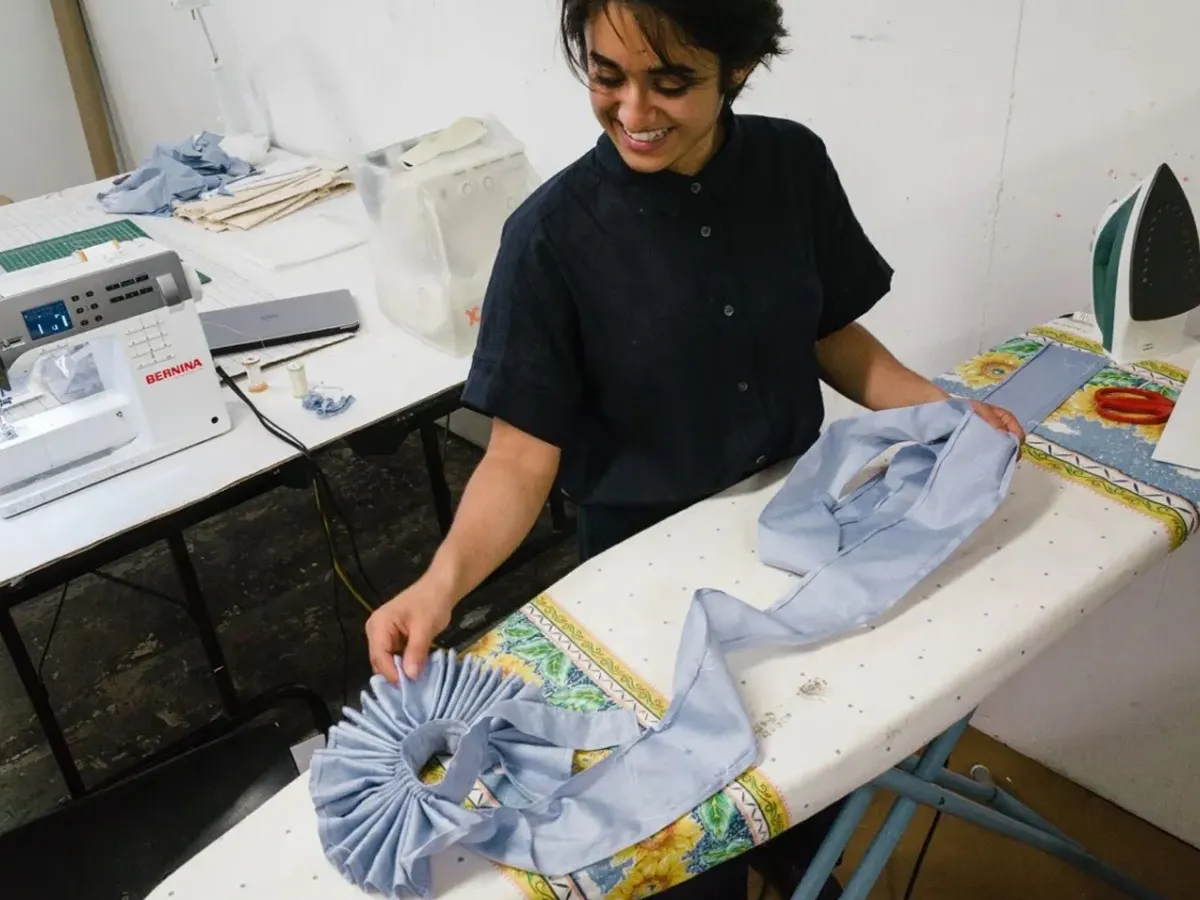 Person manipulating textiles on an ironing board