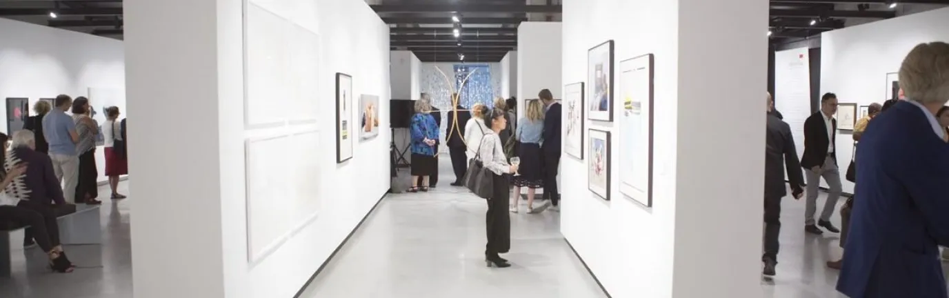 People in a gallery with white walls observing art.