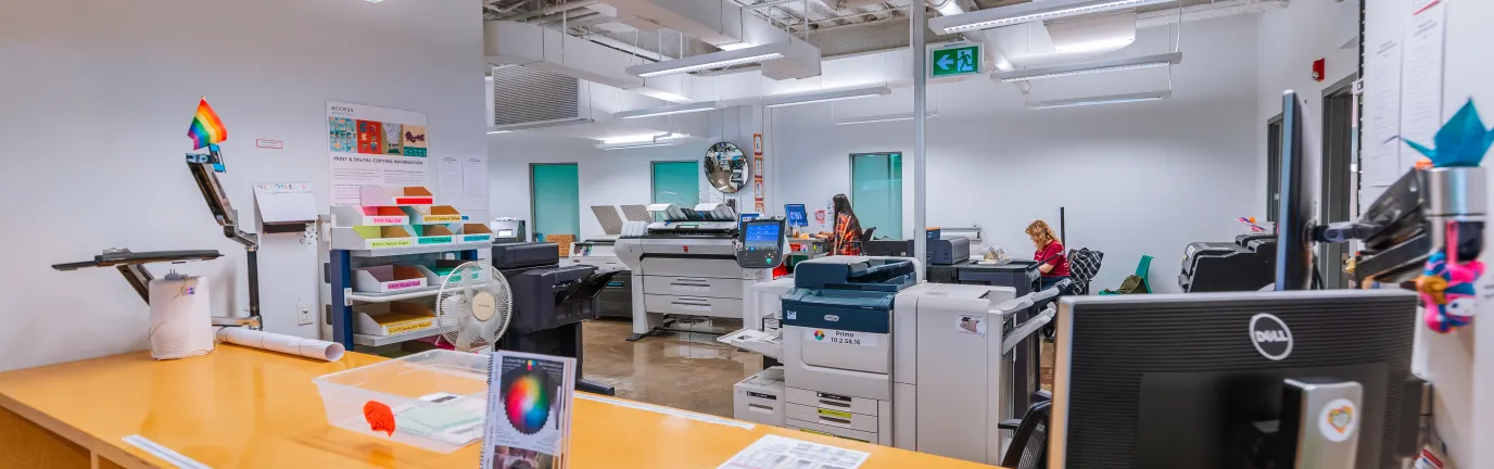 Desk in front of a room containing various printing machines.