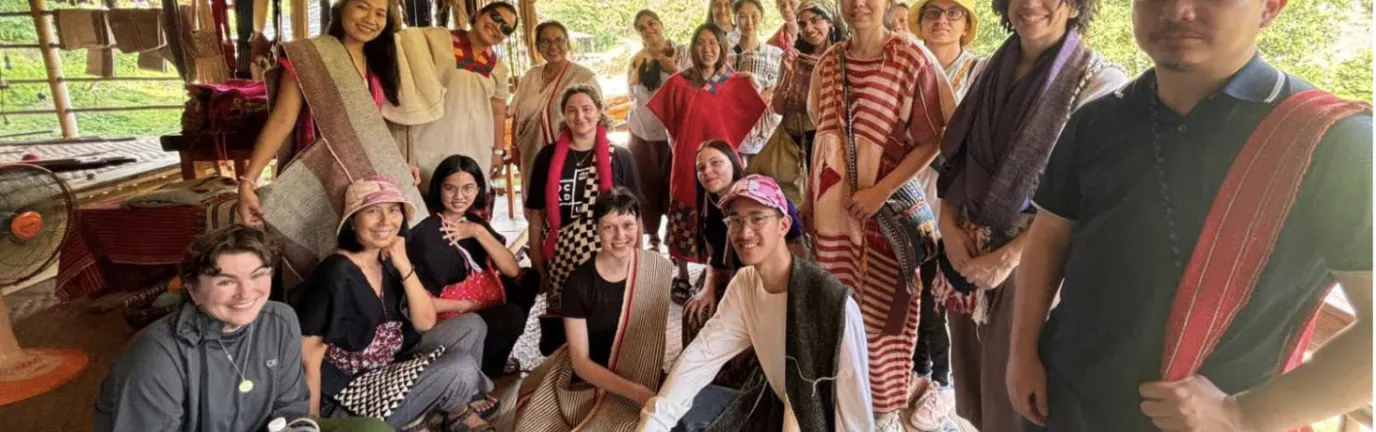 Group of people posing for a photo in an wooden structure