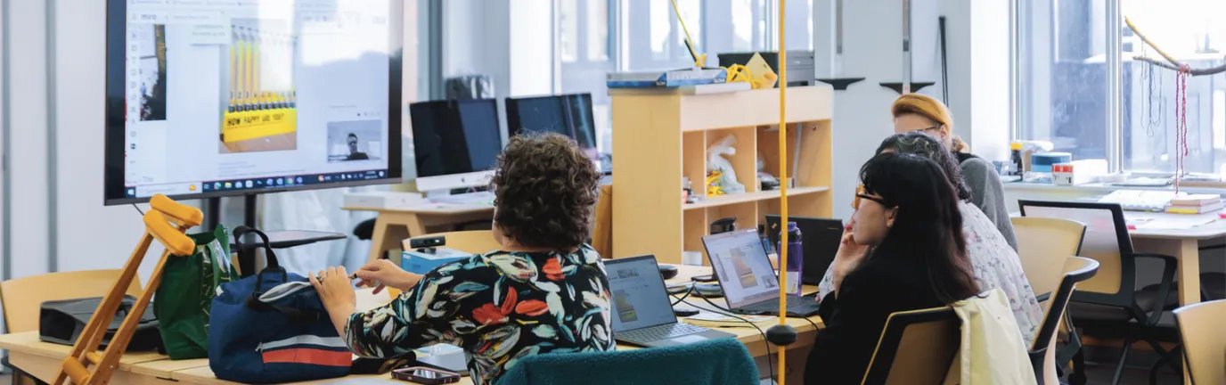 Students working together at a screen