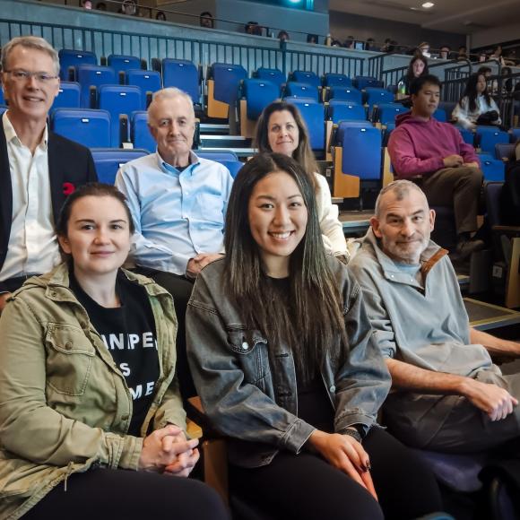 Six University of Toronto surgeons, three in top row and three in bottom row, in an auditorium at OCAD University. 