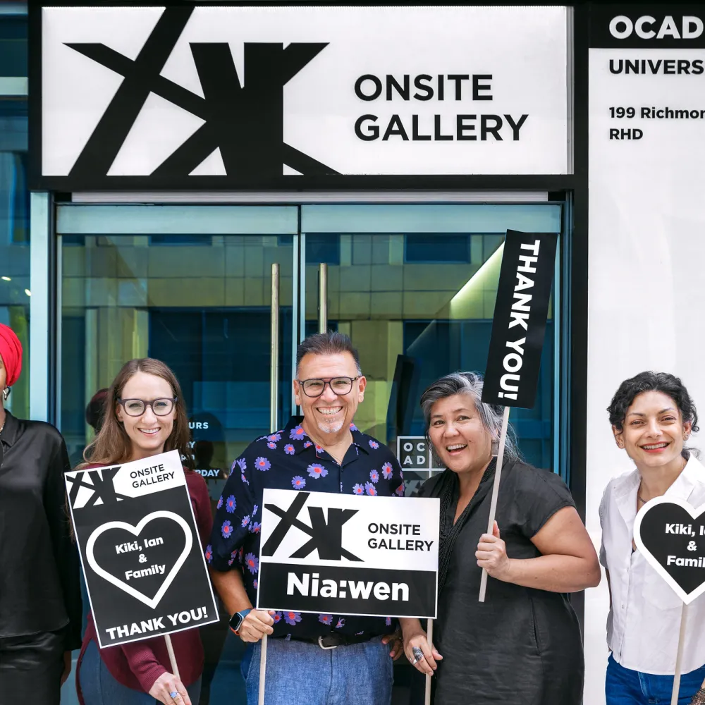 Group outside Onsite Gallery holding signs