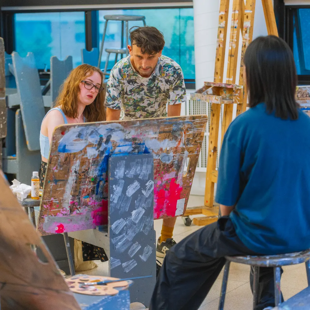 People in a room looking at artwork.