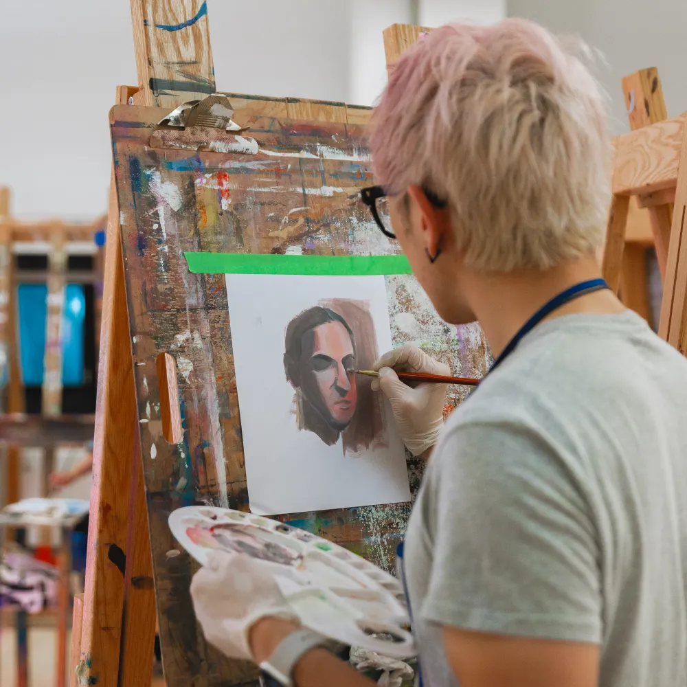 Person painting on an easel.