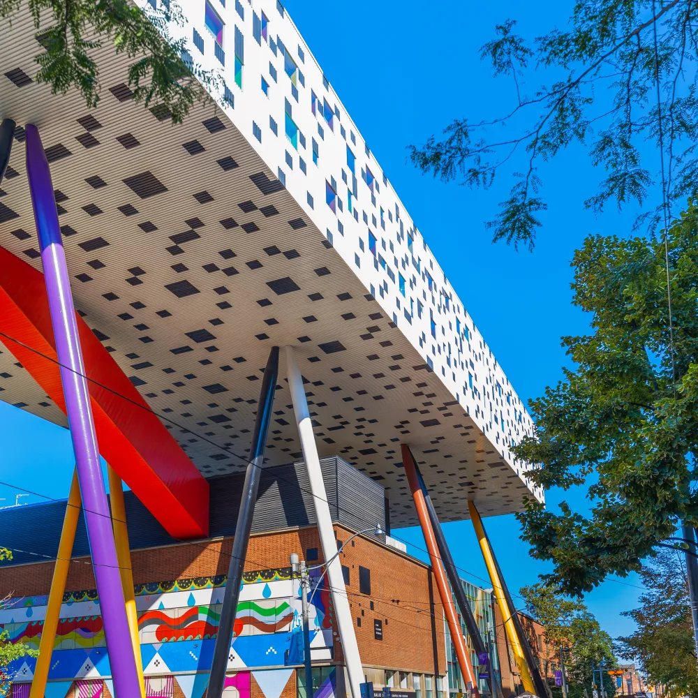 Blue sky with people gathering around a white and black checkered building.