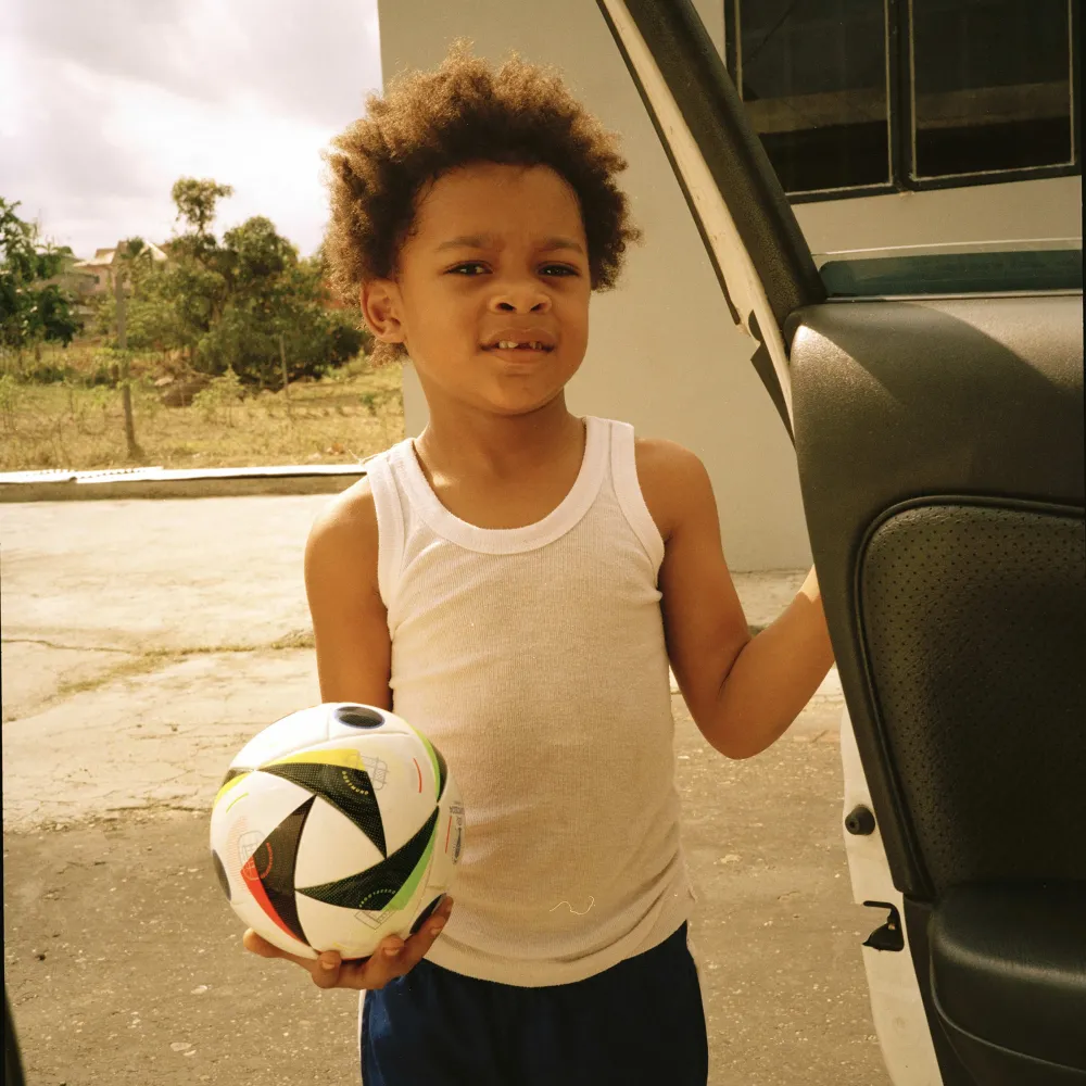 Photo of little boy from inside a car at the car door