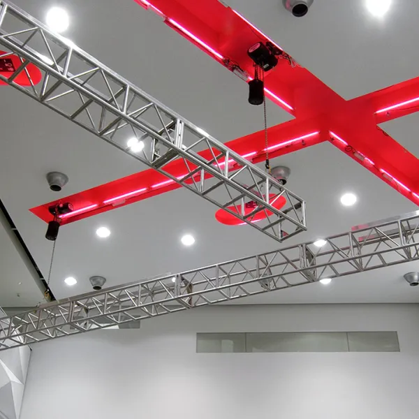 Ceiling of the Great Hall with lighting rigs and a bold red X architectural detail