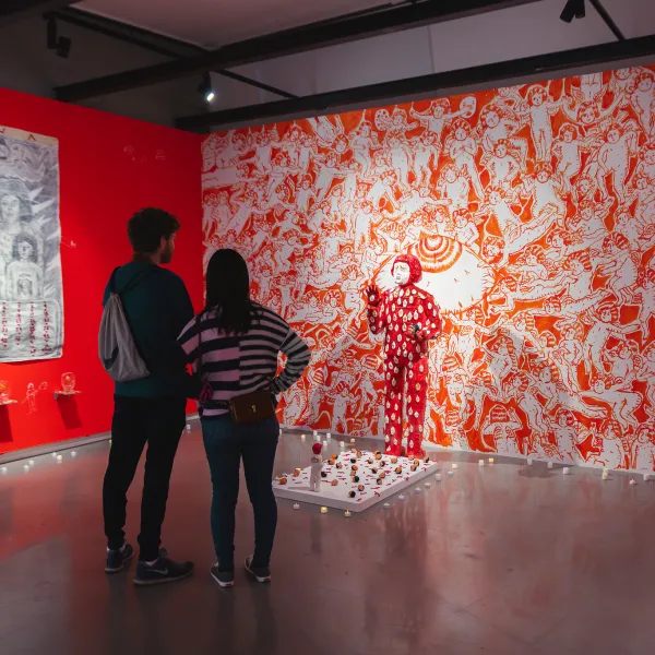 Two people looking at an art exhibit feating orange print 