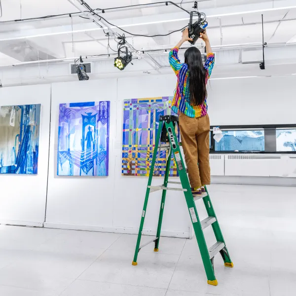 Student setting up gallery space