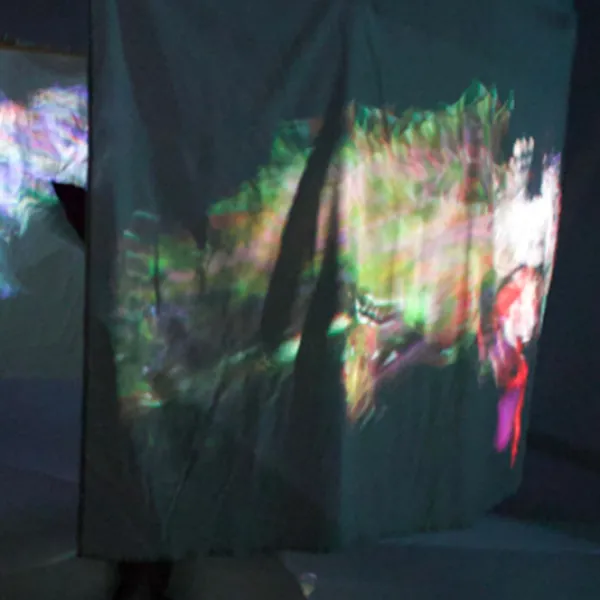 Photo of an art installation, projected images on hanging cloth