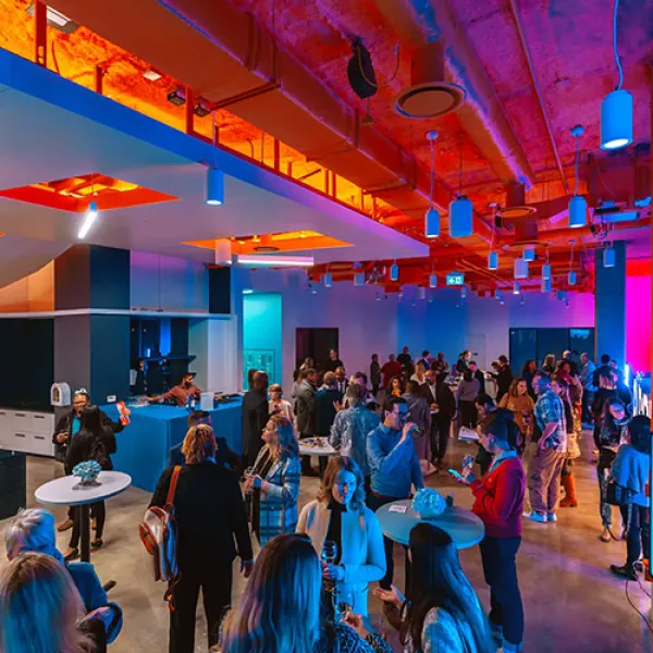 Crowded open space with an event featuring dramatic orange lighting